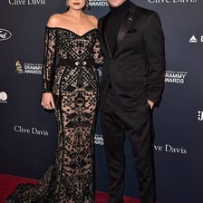 A celebrity couple standing together on a red carpet.