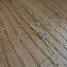 A heavy object shown falling toward a wooden floor.