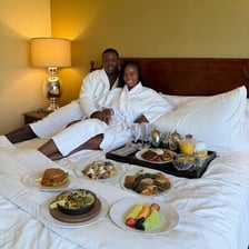 A hotel room displaying champagne and a plush robe for guests