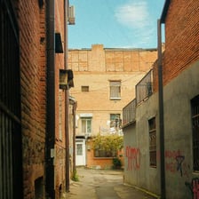 A narrow paved alley between city buildings