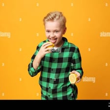 A person reacting to the sour taste of a lemon