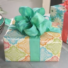 A decorative ribbon bow attached to a wrapped gift