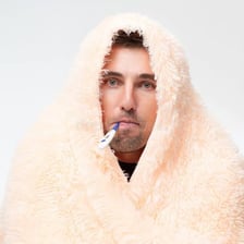 A sick person with a thermometer during winter