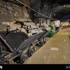 A mine cart loaded with mineral-bearing rock underground.