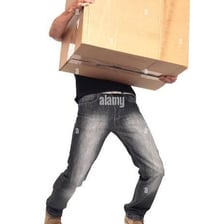 A person carrying a heavy stack of boxes