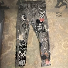 Acid-wash denim jeans styled in a punk fashion