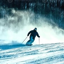 A skier descending a snow-covered mountain