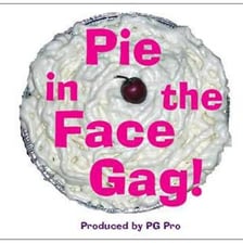 A clown being hit in the face with a cream pie