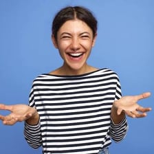 A person laughing in response to something funny.