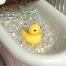 A yellow rubber duck floating in a bathtub