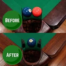 A billiards table with colored balls and a ball dropping into a pocket.