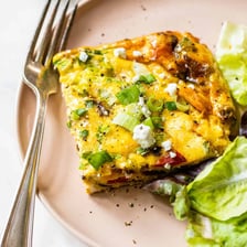 A sliced frittata containing cooked eggs and vegetables