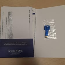 A property deed beside house keys, representing ownership.