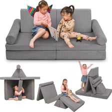 A makeshift fort built from couch cushions and blankets in a living room.