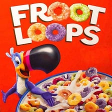 A bowl of colorful Froot Loops cereal beside the Toucan Sam mascot