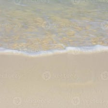 Seawater receding from a beach as the tide ebbs.