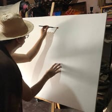 An artist beginning work on a blank canvas.