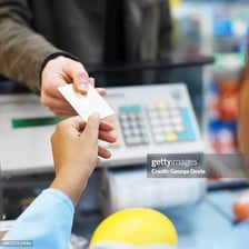 A person handing money to a cashier