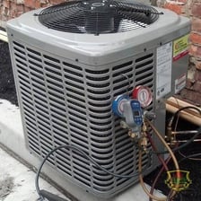 Technician servicing the refrigerant system of an air conditioner