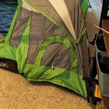 A camping tent with its fabric entrance flap open.