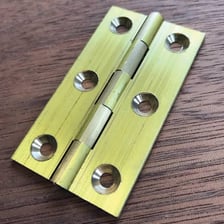 A metal hinge attached to the edge of a door