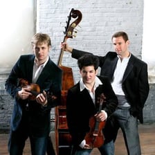 Three performers standing together as a trio