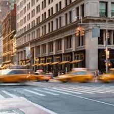 Yellow taxi cab driving on a city street