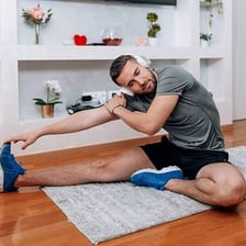An athlete stretching sore muscles after exercise