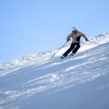 A skier descending a snow-covered slope