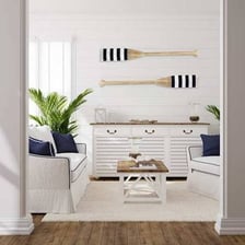 A wooden oar displayed horizontally on a boathouse wall