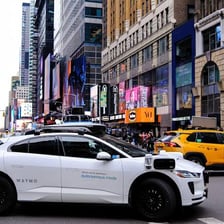 A Waymo autonomous vehicle traveling on a city street.