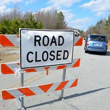 A road blocked by barricades representing a roadblock.