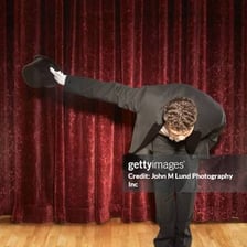 A performer bowing to an audience after a performance