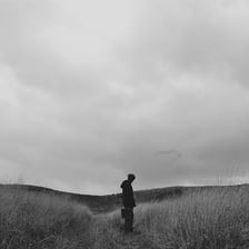 A solitary person standing in an otherwise empty landscape