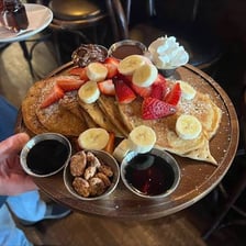 A restaurant plate showing several small pancakes in different flavors.