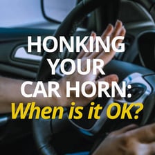 A car on a road with a driver sounding its horn