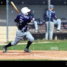 A baseball batter hitting while a runner scores.
