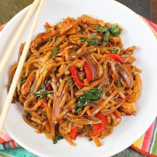 A plate of Thai pad kee mao made with wide rice noodles