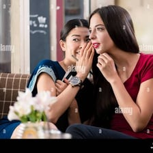 People confiding in one another as they share a secret