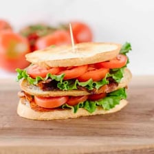 A bacon, lettuce, and tomato sandwich secured with toothpicks