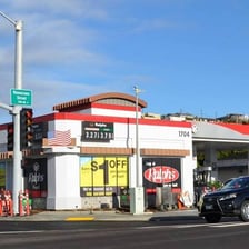 A Shell-branded gas station and a seashell in a beach setting.