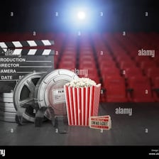 A film reel beside a movie theater screen.