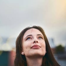 A hopeful person looking upward with an optimistic expression.