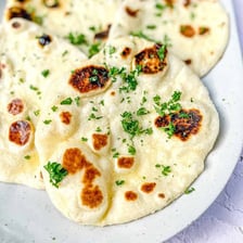 A piece of naan flatbread brushed with garlic butter