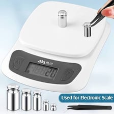 A small calibration weight beside a digital scale.