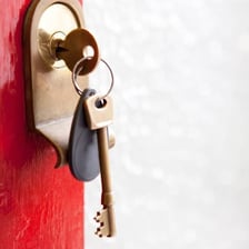 A set of house keys lying inside a home near a locked front door.