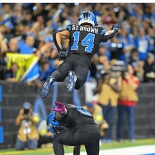 An American football player celebrating after scoring in the end zone