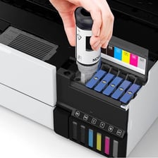 An ink cartridge positioned beside a printer.