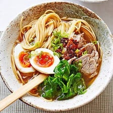A bowl of ramen noodles in rich broth with toppings