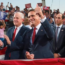 A politician publicly endorsing another candidate at a campaign event.